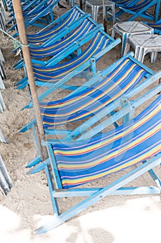 Rental beach canvas chairs and white table on natural white sand