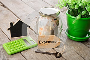 Rental concept - money jar, key with label and little house on the wooden desk