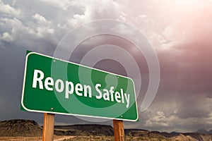 Reopen Safely Green Road Sign Against Ominous Stormy Cloudy Sky