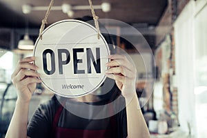 Reopen. waitress woman turning open sign board reopen after coronavirus quarantine is over in modern cafe coffee shop ready to ser