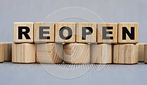 REOPEN - word on wooden cubes on a beautiful gray background