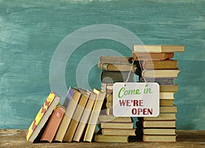 Reopening bookshops after the corona lockdown, stack of books and open sign,symbolic