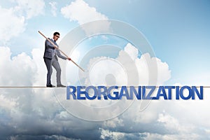 The reorganisation concept with businessman walking on tight rope