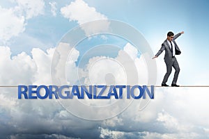 The reorganisation concept with businessman walking on tight rope