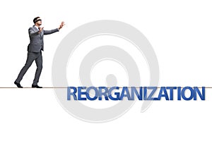 The reorganisation concept with businessman walking on tight rope