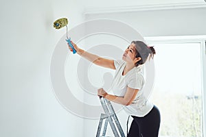 Repair in the apartment, the girl makes repairs in the apartment, paint the walls with a roller