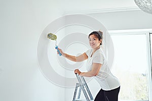 Repair in the apartment, the girl makes repairs in the apartment, paint the walls with a roller