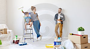 Repair in apartment. Happy family mother, father and child daughter  paints wall photo