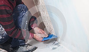 Repair the apartment. Worker glues the wallpaper to the wall