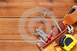 Different work tools in belt on wooden boards