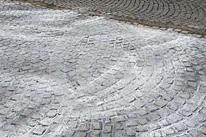 Repair of cobblestone road. between the joints of the cube is poured asphalt which is sprinkled from the top with fine white silic