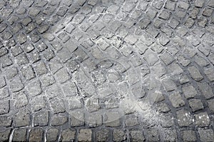 Repair of cobblestone road. between the joints of the cube is poured asphalt which is sprinkled from the top with fine white silic