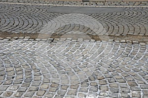 Repair of cobblestone road. between the joints of the cube is poured asphalt which is sprinkled from the top with fine white silic