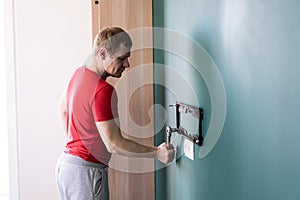 Repair and decoration. `husband for an hour` service. a man attaches a TV mount to a wall.