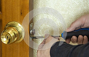 Repair of the door lock. A man repairs a lock