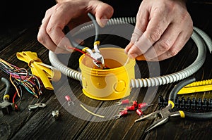 Repair of electrical equipment in the workshop of a master electrician. Close-up of the hands of a master electrician while