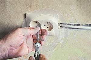 Repair of electrical outlets in the wall of the house.Old broken light switch with power connection in old broken factory.