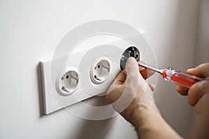 Repair electricity socket man with bare hands. Improper safety or repair of the electrical outlet