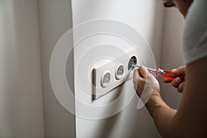 Repair electricity socket man with bare hands. Incorrect safety or repair of the electrical outlet