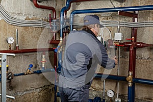 Repair engineer for heating system equipment in the basement of a building. Plumbing, maintenance and repair.