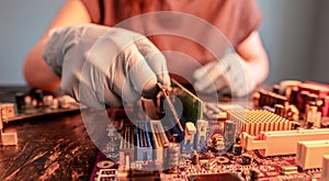 A repair engineer holds a RAM chip with his hands, inserts the RAM into the socket of the computer`s motherboard