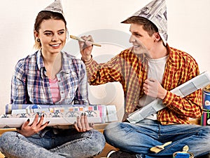 Repair family by happy couple building home using spirit level to measure.