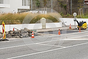 Repair fragment of tarmac on road surface, pile of old uncovered tarmac, minor repairs.