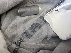 Repair garments, stitched seams on a worn jeans trousers with the sewing machine