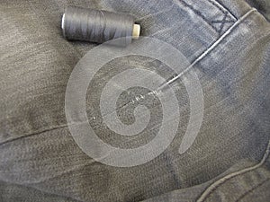 Repair garments, stitched seams on a worn jeans trousers with the sewing machine