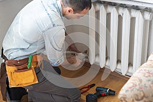 Repair heating radiator close-up. man repairing radiator