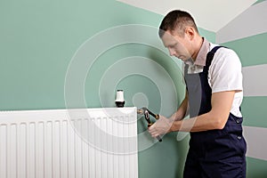 Repair heating radiator close-up. man repairing radiator with wrench.