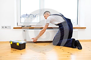 Repair heating radiator close-up. man repairing radiator with wrench.