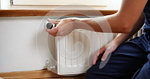 Repair heating radiator close-up. man repairing radiator with wrench.