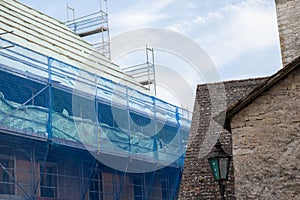 repair a house. Home construction.Construction and repair of the house.Scaffolding in a protective blue grid against a