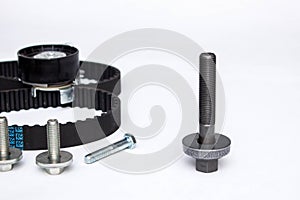 Repair kit: gear belt and bolts isolated on a white background. Car spare parts