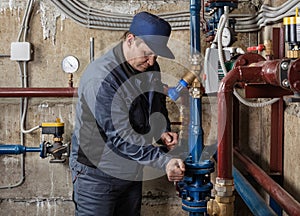 Repair and maintenance engineer for heating system equipment in the basement of a building.