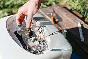 Repair and maintenance of the water heater. Men`s hands holding detail for repair. Close up