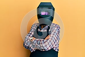 Repair man wearing professional welding mask over head covering face for protection