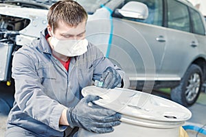 Repair mechanic worker with light alloy car wheel disk rim