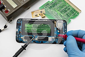 Repair of a mobile phone, with various electronic circuits in the background