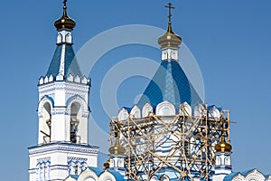 The repair of the Orthodox Church scaffolding on the tower, a blue roof and blue sky