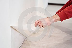 Repair and renovate the interior of the house with their own hands. Close-up of the moment of tearing the old wallpaper off the