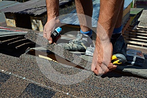 Repair of a Roofing from shingles. Roofer cutting roofing felt or bitumen during waterproofing works. Roof Shingles - Roofing. photo