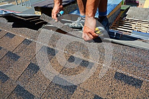 Repair of a Roofing from shingles. Roofer cutting roofing felt or bitumen during waterproofing works. Roof Shingles - Roofing. photo