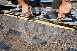 Repair of a Roofing from shingles. Roofer cutting roofing felt or bitumen during waterproofing works. Roof Shingles - Roofing.