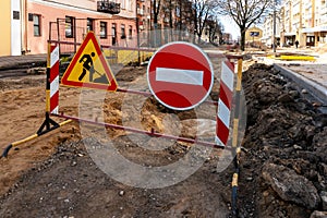 repair of sidewalks and roads in the city. A section of the street closed from traffic. A road sign signifying a dangerous zone