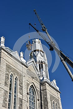 Repair of the steeple of the church of Saint-Pie in Quebec with two cranes