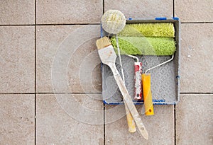 Repair tools over stone floor tile background. Copy space.