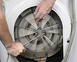Repair of washing machines. Plumber removes parts from a washing machine