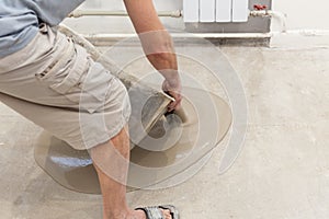 Repair work. Pouring floors in the room. Fill screed floor repair and furnish. Worker pouring concrete on the floor